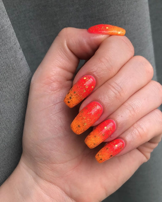 Orange Glittering Nails for Weeding Guests: Vibrant orange nails adorned with shimmering glitter.