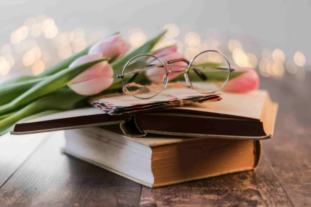 Two books with tulips and glasses showcasing best books 2024. Free to use Pexel picture.