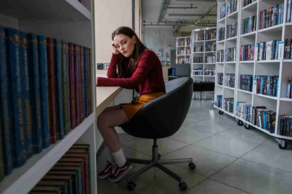 Girl posing while sitting in a library.