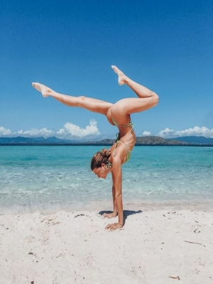 girl doing a handstand at the shore