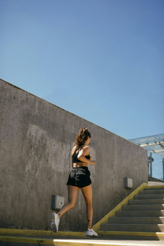 girl running upstairs outside in black gym clothes