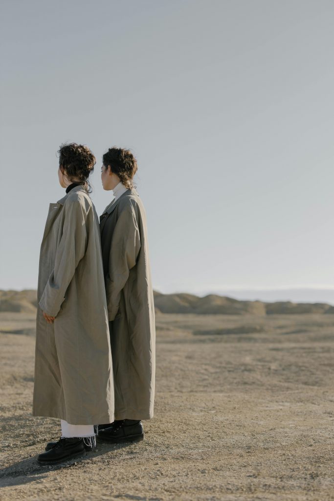 two girls standing in the desert with long brown winter coats fall 2024 fashion trends