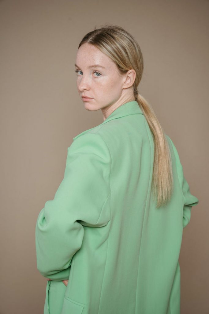 girl in green blazer and slickback ponytail fall 2024 fashion trends