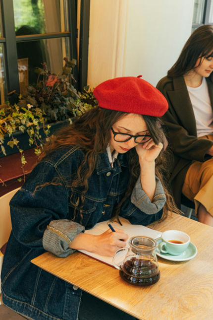 woman journaling in a cafe