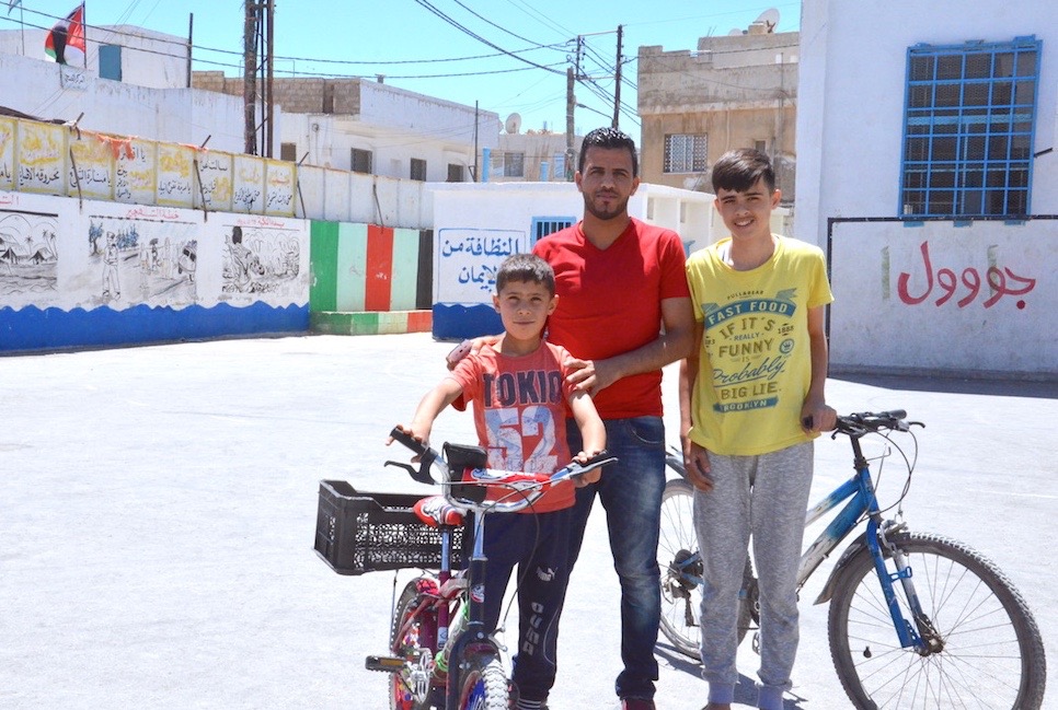 Ismail standing in the schoolyard with some of his students in Madabaa. Photo: Souha Al-Mersal/The Turban Times