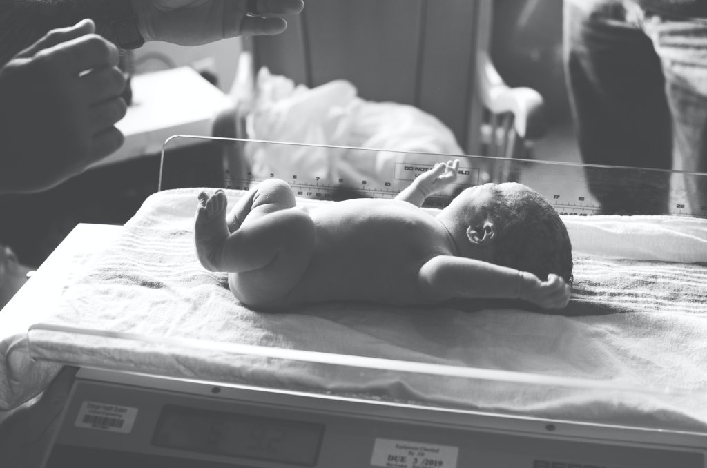 Naked newborn lying on scales