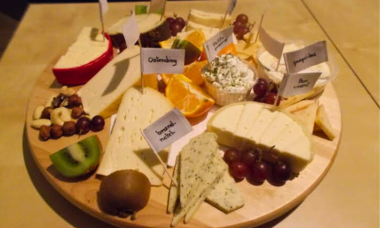 Verschillende soorten kaas op een ronde kaasplank.