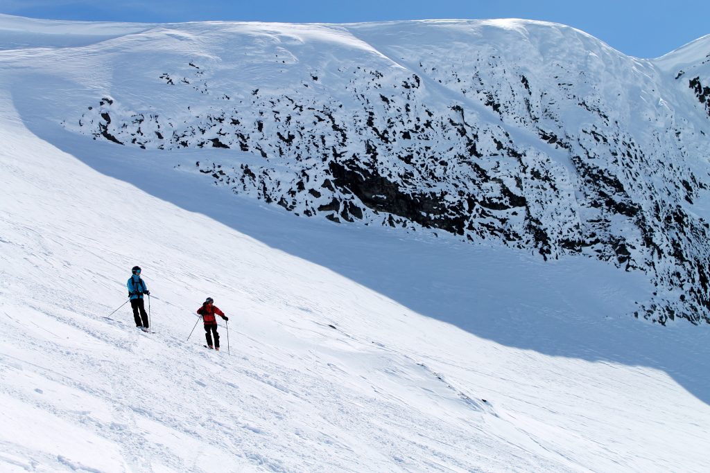 Skikjørere på vei ned fra Steindaslnosi.