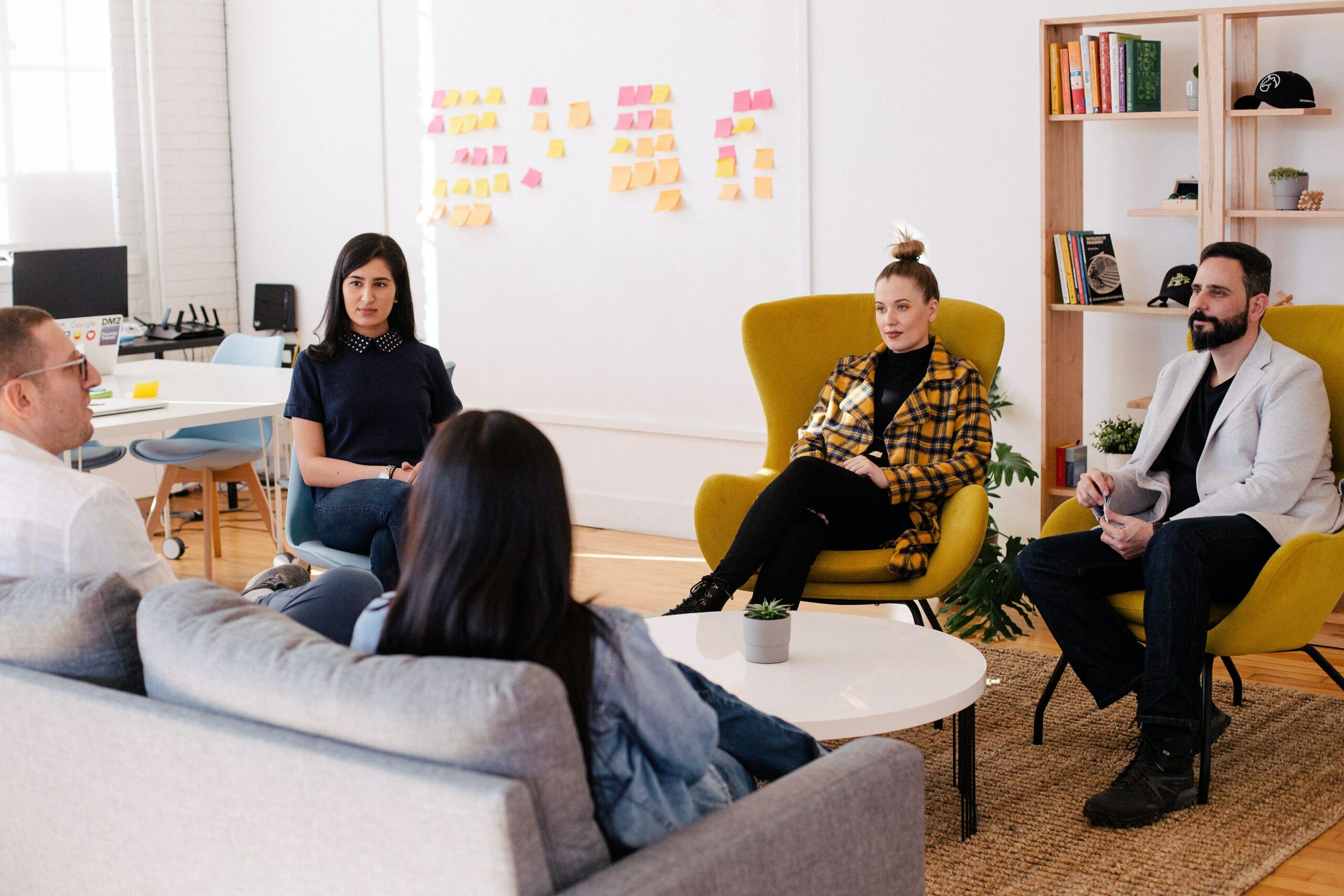 People seated in a meeting room, going through the five stages of team development