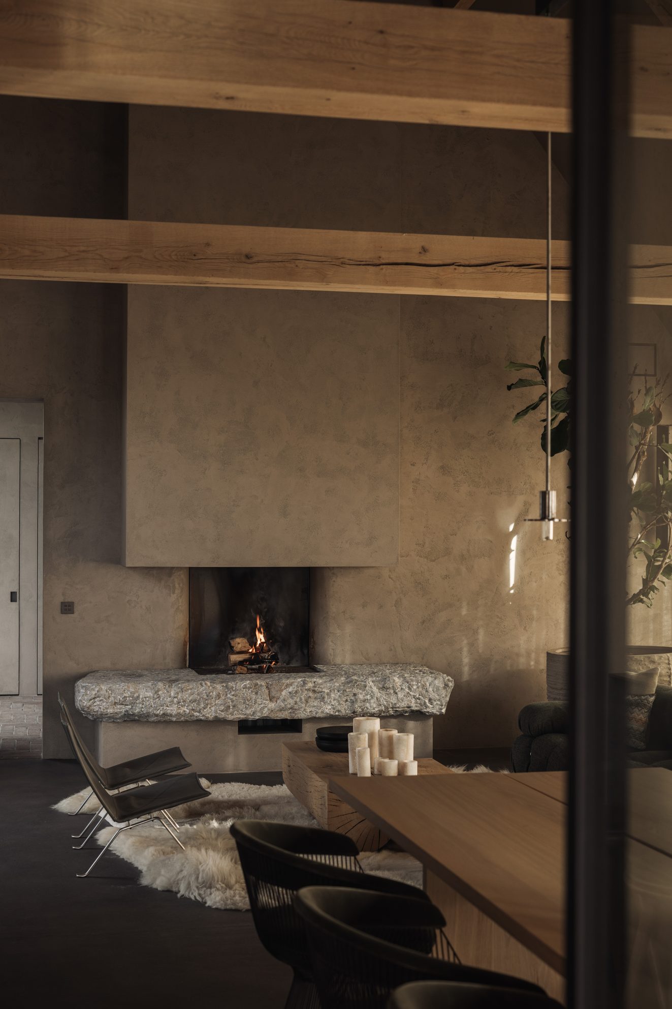 Leefruimte met open haard, houten balken en lange eettafel