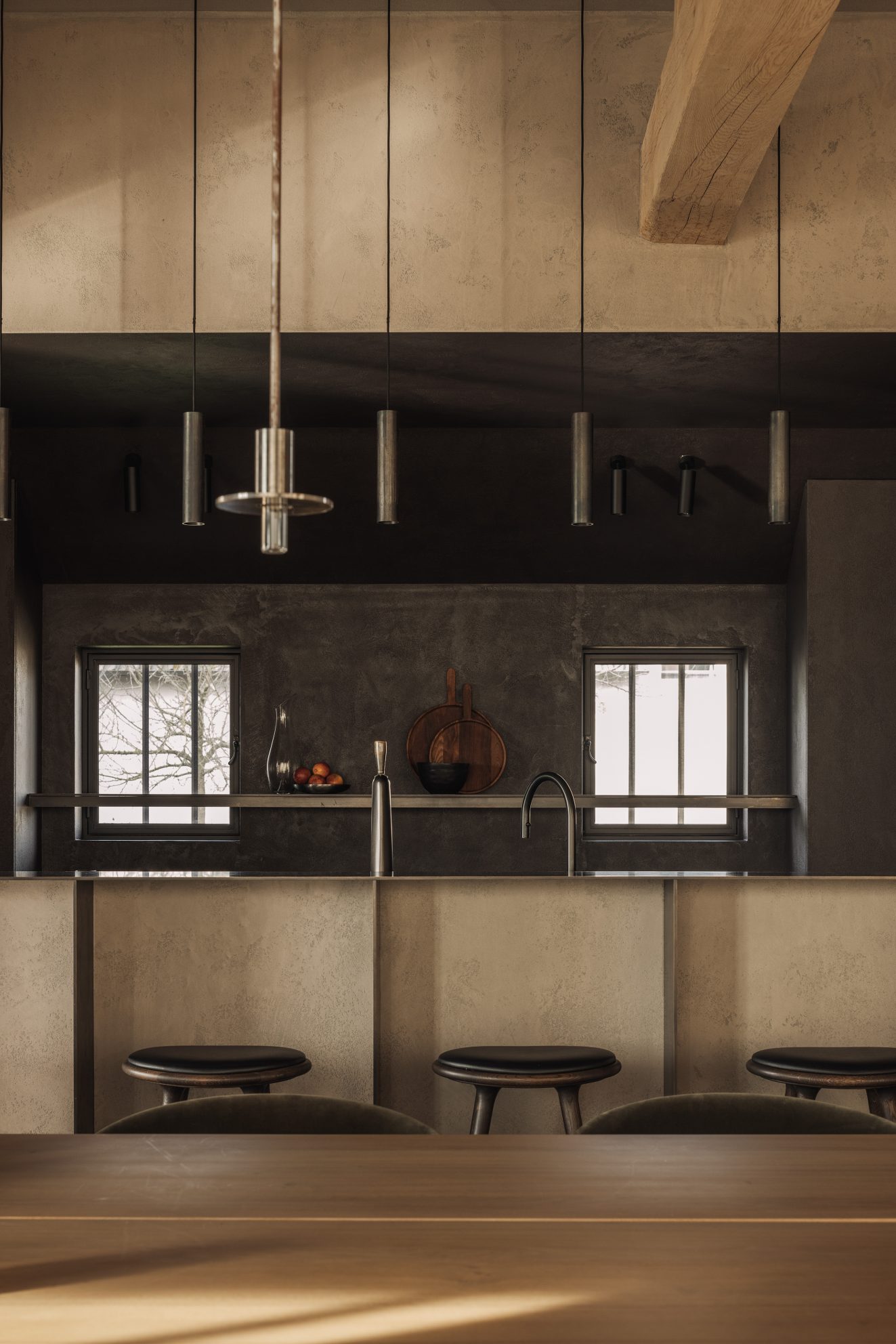 Keuken met strakke bar, twee ramen en verticale pendellampen