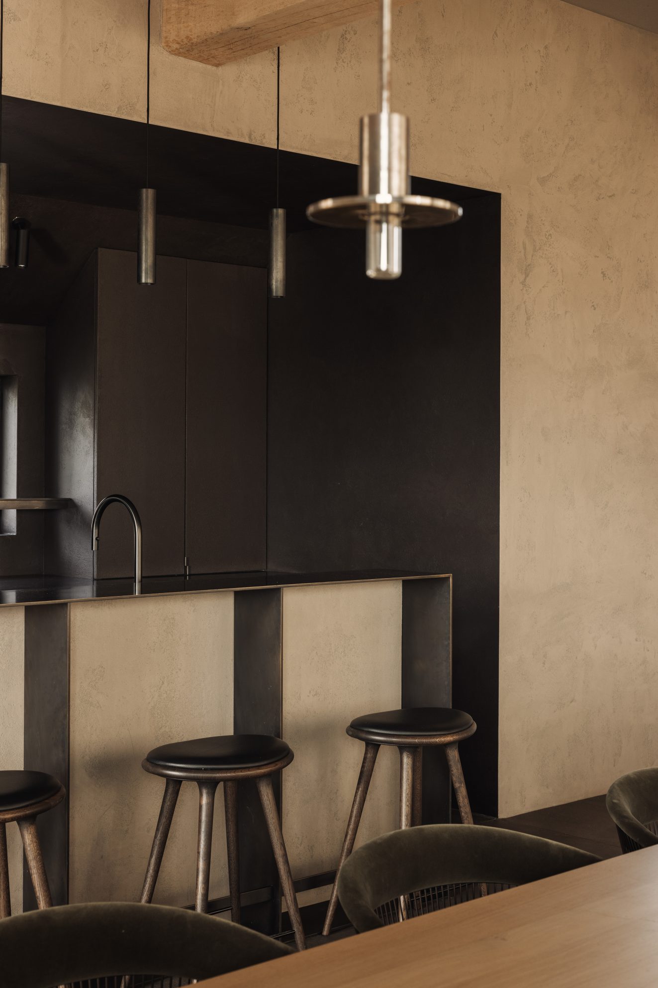 Detail van keukenbar met hanglamp en donkere achterwand