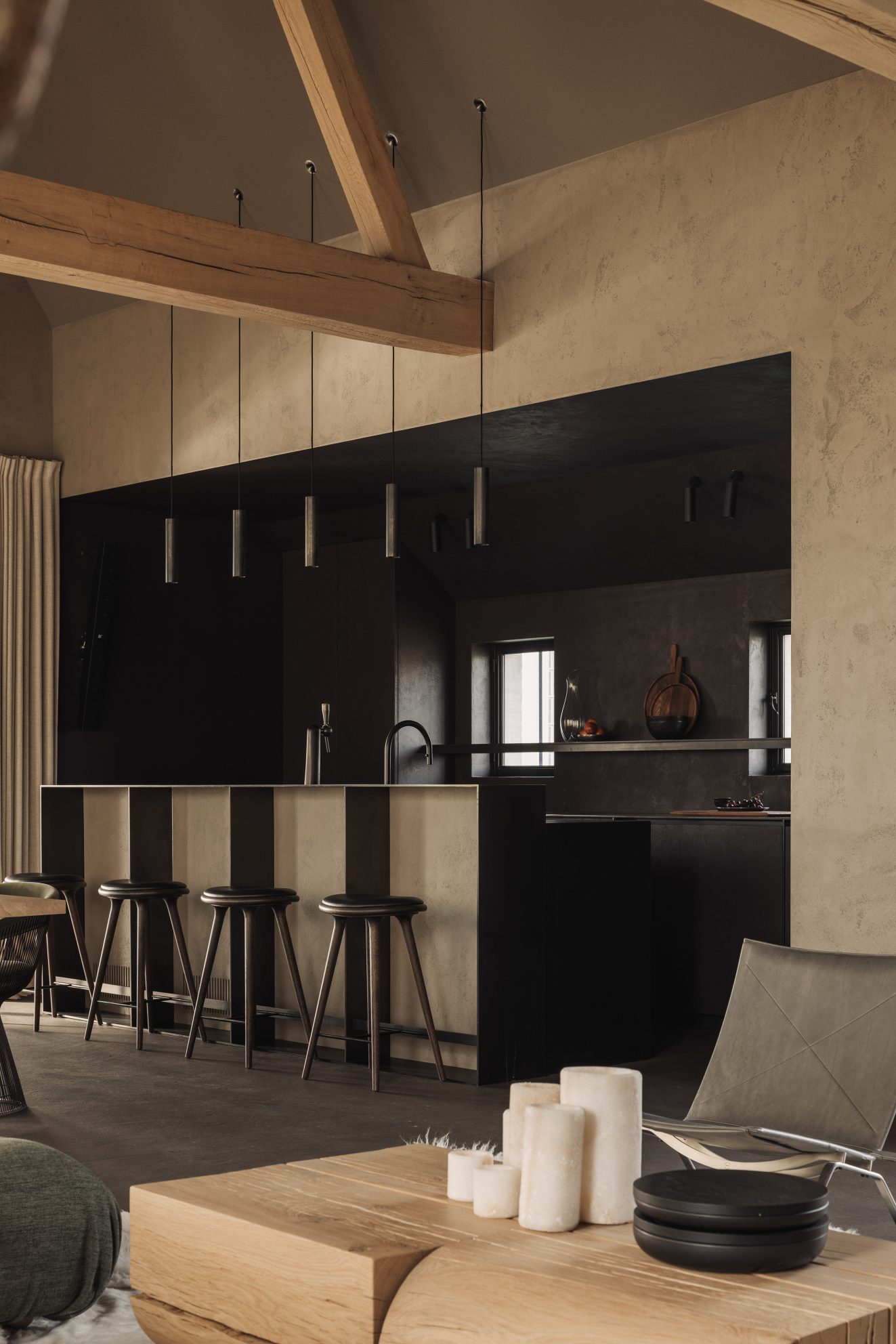 Keuken met lange bar, pendellampen en zichtbare houten balken