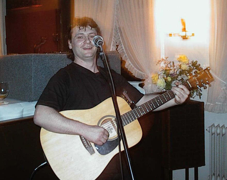 der Alleinunterhalter, Sänger und Gitarrist Torsten Q aus Hamburg mit Gitarre vor einem Mikrofonständer während eines Auftritts bei einer Hochzeit