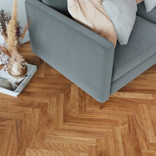 A cozy modern living room corner with wooden parquet flooring featuring a gray sofa a stylish coffee table and decorative frames and booksxAxA
