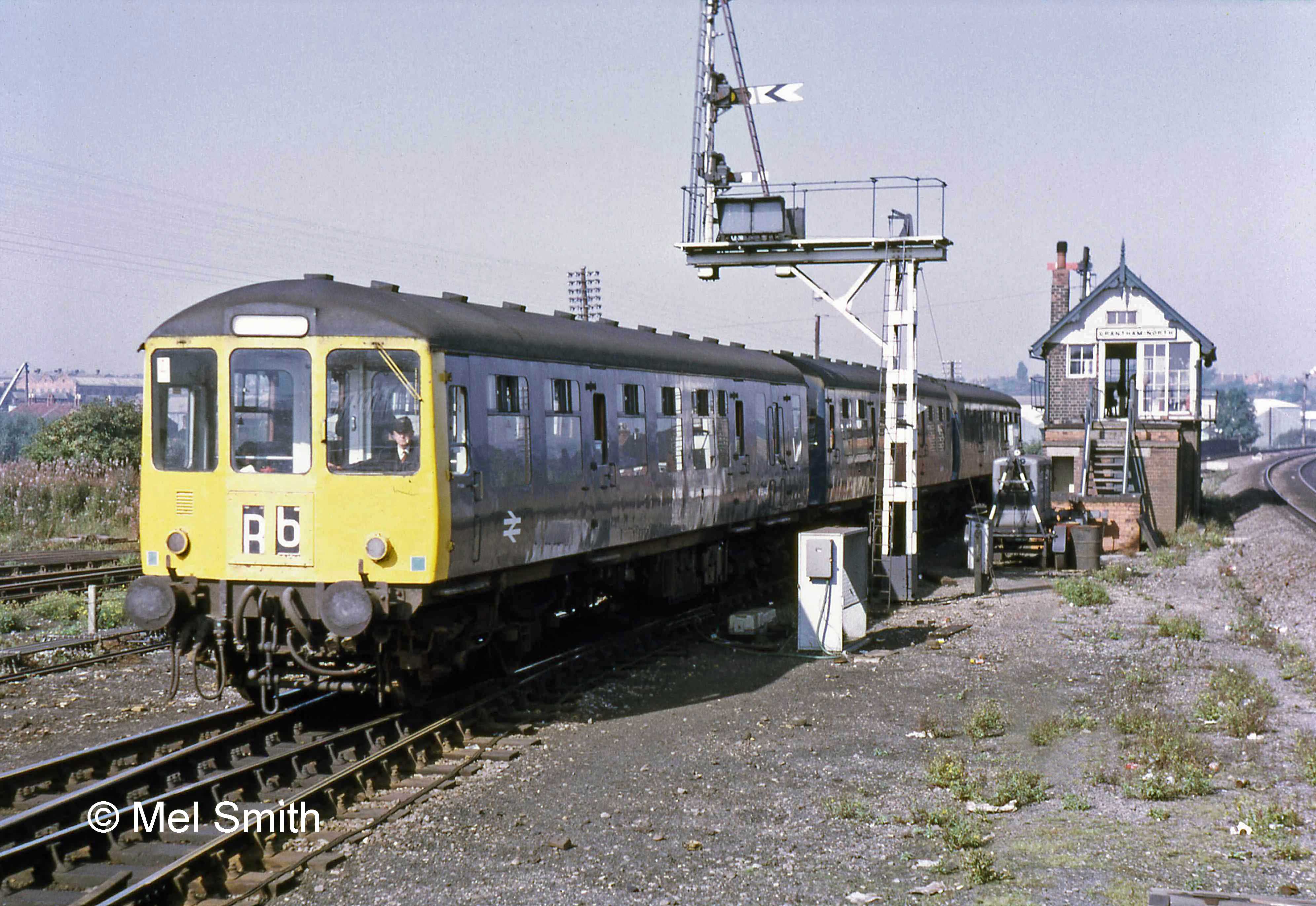 On the same day in October 1971 a local train arrives from the Nottingham line and approaches the Western platform. The signal post at this point is at the same site as one seen previously but it is a new structure, provided to allow a distant signal arm to be added. Until April 1970, when a new link was provided at Barrowby Road, there was a connection into the Down Main line here in the area between the photographer and the signal box. Photograph by Mel Smith.