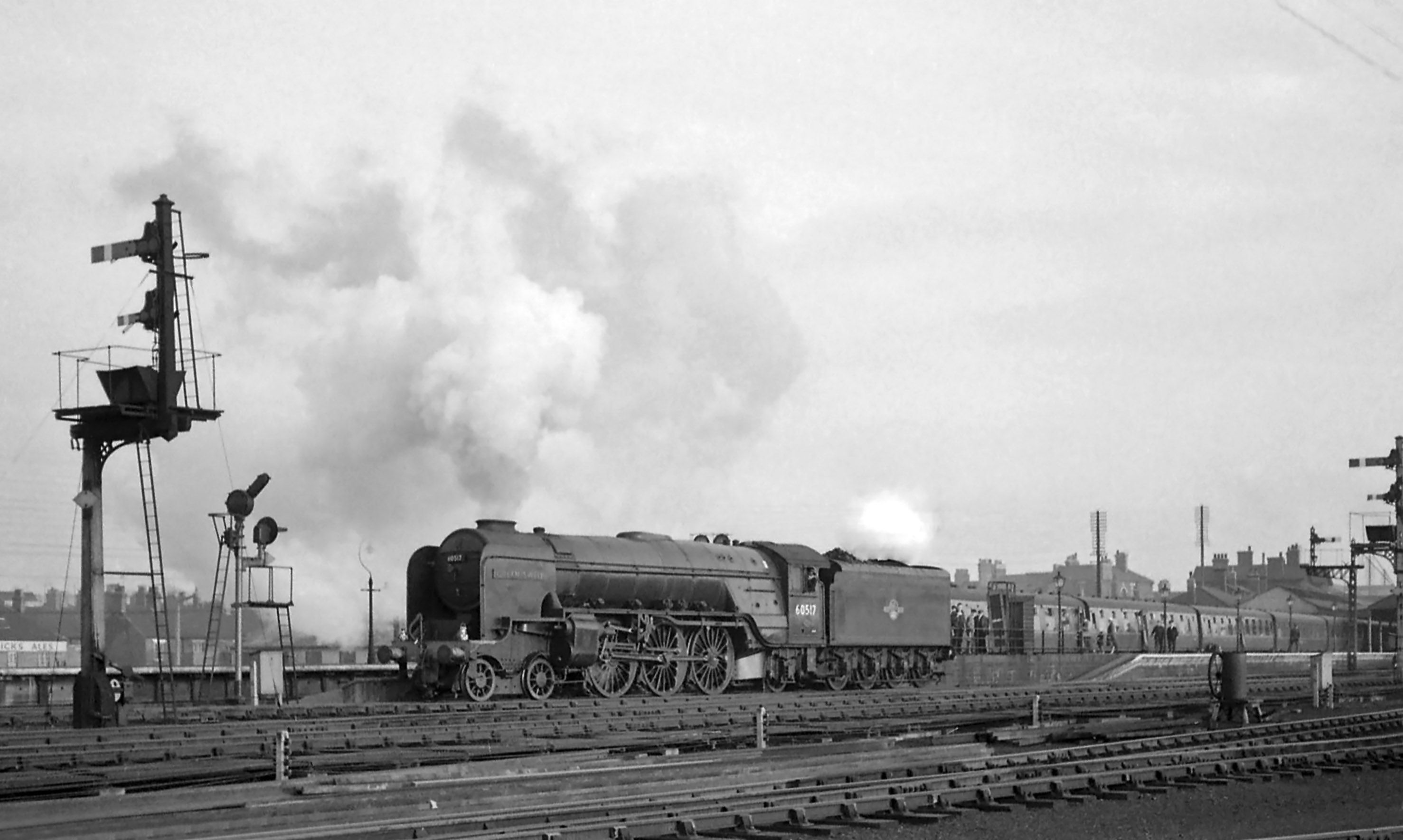 With No.60003 is clear the signalman has set the route for No. 60517 onto the Main line through the connection three tracks over from the photographer. Seeing the the disc shunt signal clear, its driver is running forward onto the Main line; a final set of points for the signalman to return to ‘normal’ and No. 60517 will set back to be coupled to the train and make ready for the onward journey. Photograph taken by Noel Ingram, used with permission from Steam World.