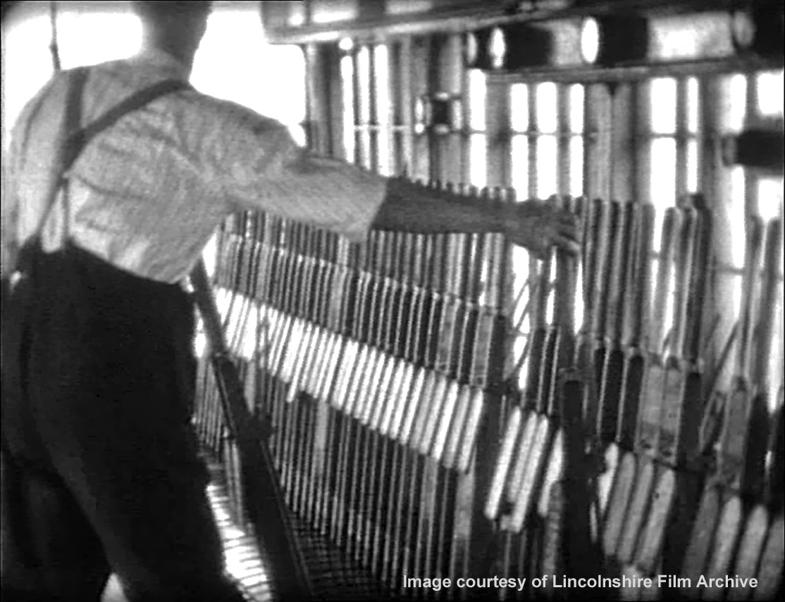 The signalman’s glance through the window is probably a check that the signal is responding correctly as its lever is pulled over. From a film shot by Walter Lee. © Lincolnshire Film Archive