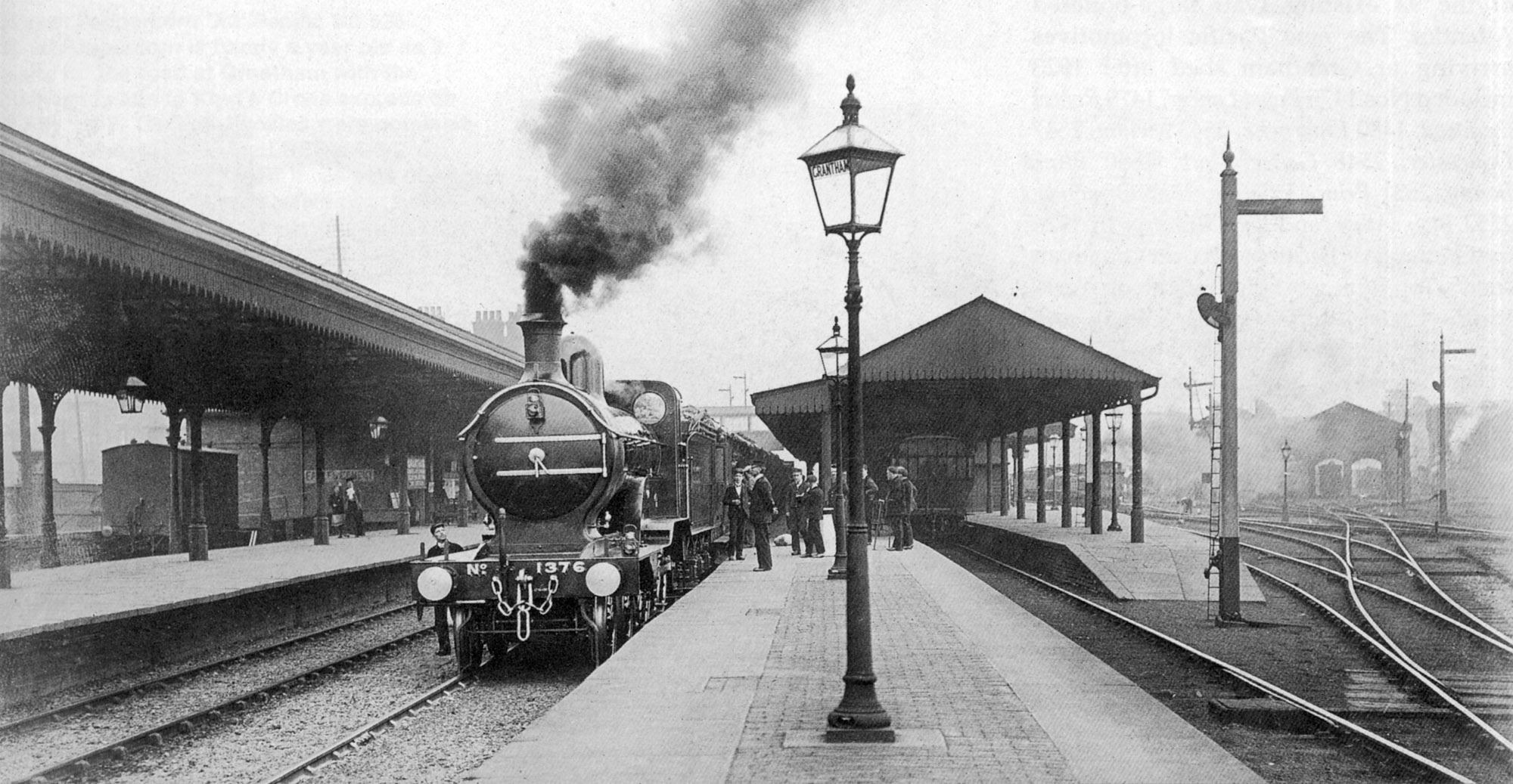 This marvellous panorama of the north end of Grantham station was taken on 17th June 1902. It records the arrangement of the track and signalling before improvements of 1903 changed much of the layout on the right, as will be explained in the next section. The nearest signal is Grantham North's starting signal for the Lincoln bay platform, under the canopy. It has a somersault arm with its lamp and spectacle mounted several feet below, as was conventional on the GNR until about the turn of the century. Its post, however, remains from the much earlier period of slotted post signalling, as can be seen from the slight increase in width just above the point where the lamp and spectacle are fitted. The starting signal for the Nottingham platform is on the platform itself - its post can be seen to the left of the second canopy support column. Its arm also originally worked in a slot in the post, as is clearly evident in this photograph. Right at the centre of the picture there's a glimpse, above the station footbridge, of the co-acting Up Main line starting signal arms at the Yard Box, demonstrating their visibility to approaching drivers from a distance. Photograph taken by Rev. T.B. Parley.