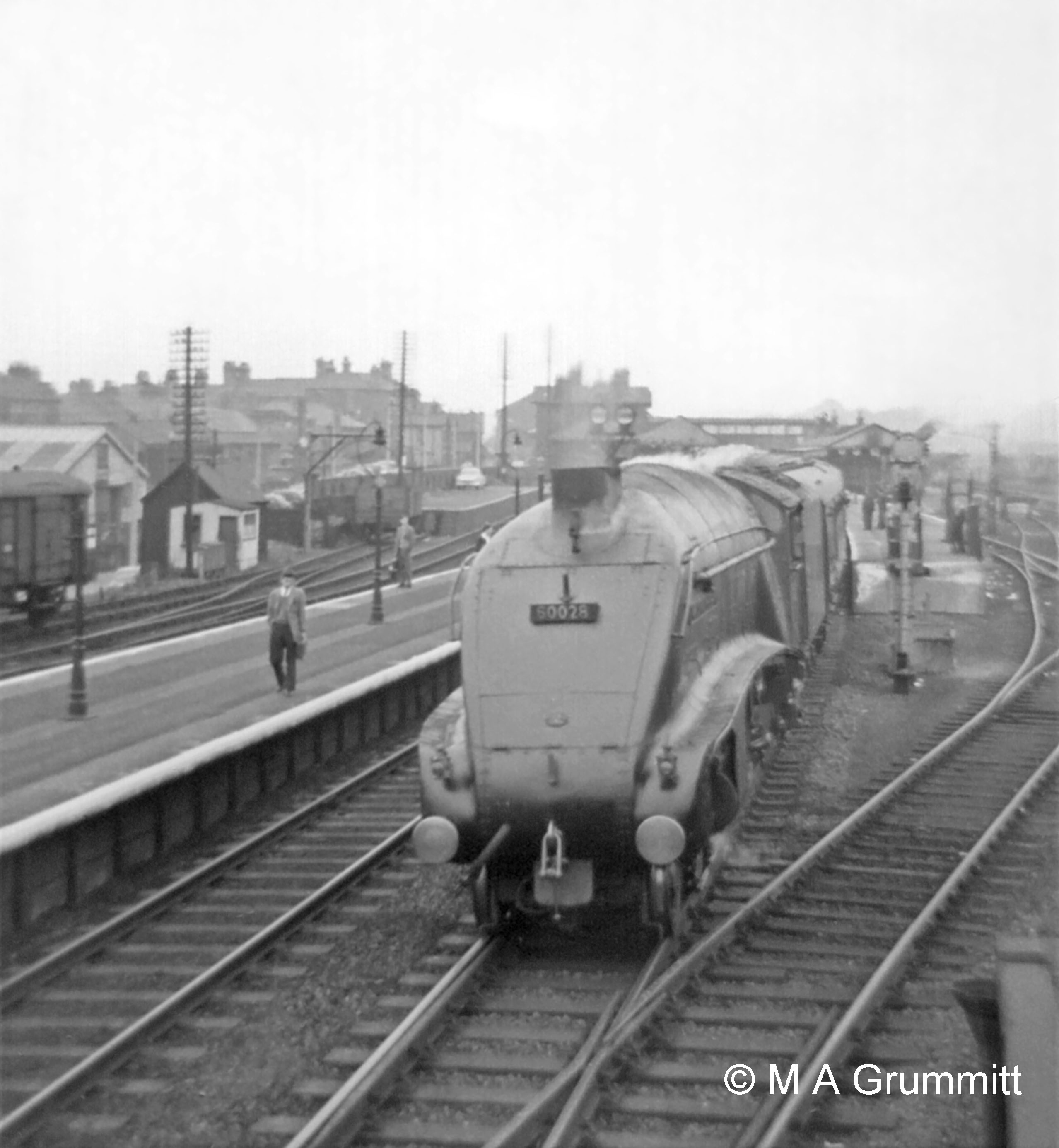 No. 60028 Walter K Wigham moves off northbound. Part of the CCT seen in the above photograph is visible again on the far left, with the end-loading facility for road vehicles in the background. The time would be about 1.45pm because walking along the platform is Barry Booth, another Telegraph Lad who is about to relieve Mick in the North Box at the 2pm shift change. Barry is the son of one of the downside station inspectors, Walter Booth. Photograph by Mick Grummitt.