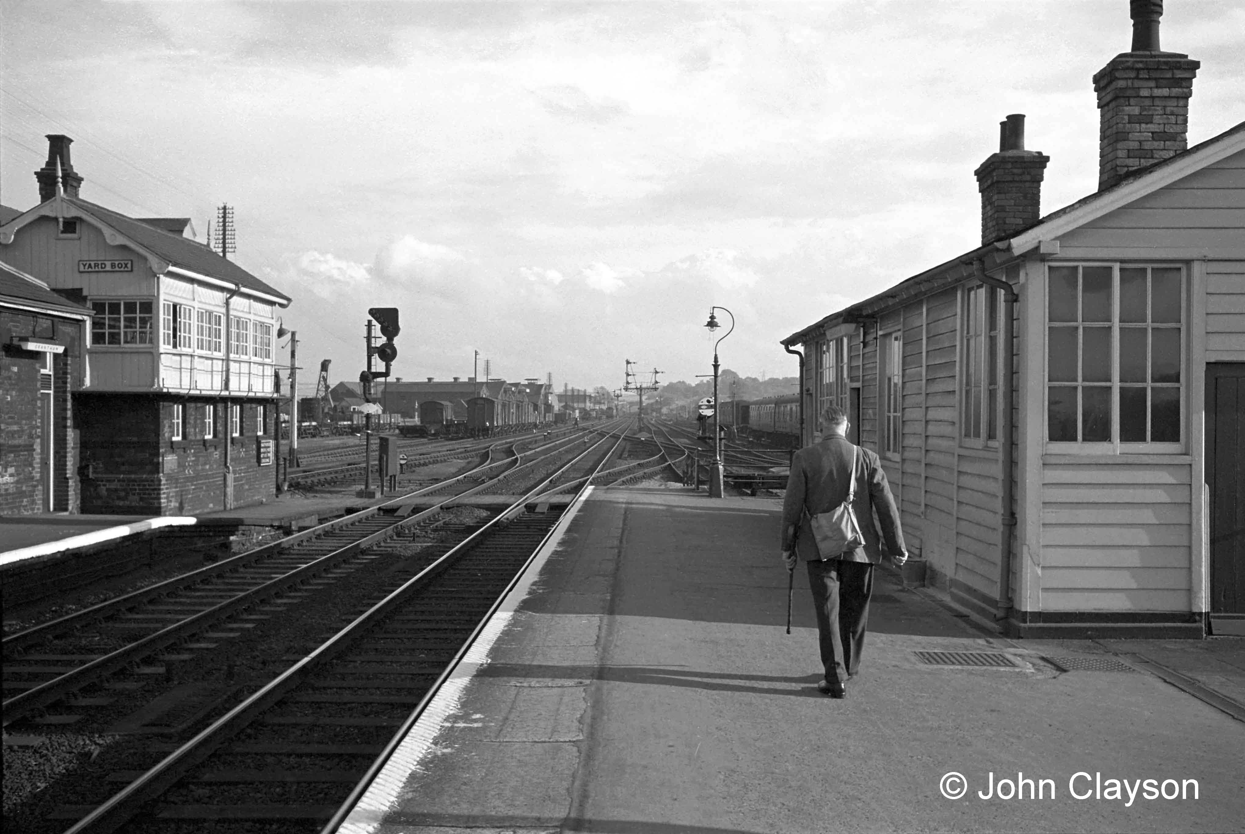 This photograph, taken on 3rd October 1963, illustrates most of the area controlled by the Yard Box (on the left). Leading in from the left is the Up (southbound) Main line. The colour light signal controls its connection, just beyond the barrow crossing, with the Up Goods line. Approaching from the far distance, and to the left of the prominent semaphore signals, is the Down (northbound) Main line. Approaching to the right of the same semaphore signal is the Down Slow line, leading to the Western platform which is on the other side of the wooden building on our right. There is a connection into the Down Main line at the platform end. Just discernible this side of the signal post is a series of diagonal crossings which connect the Western platform with three of the four running lines (Up Goods, Up Main and Down Slow) - please see the enlarged view below. Photograph by Cedric A. Clayson.