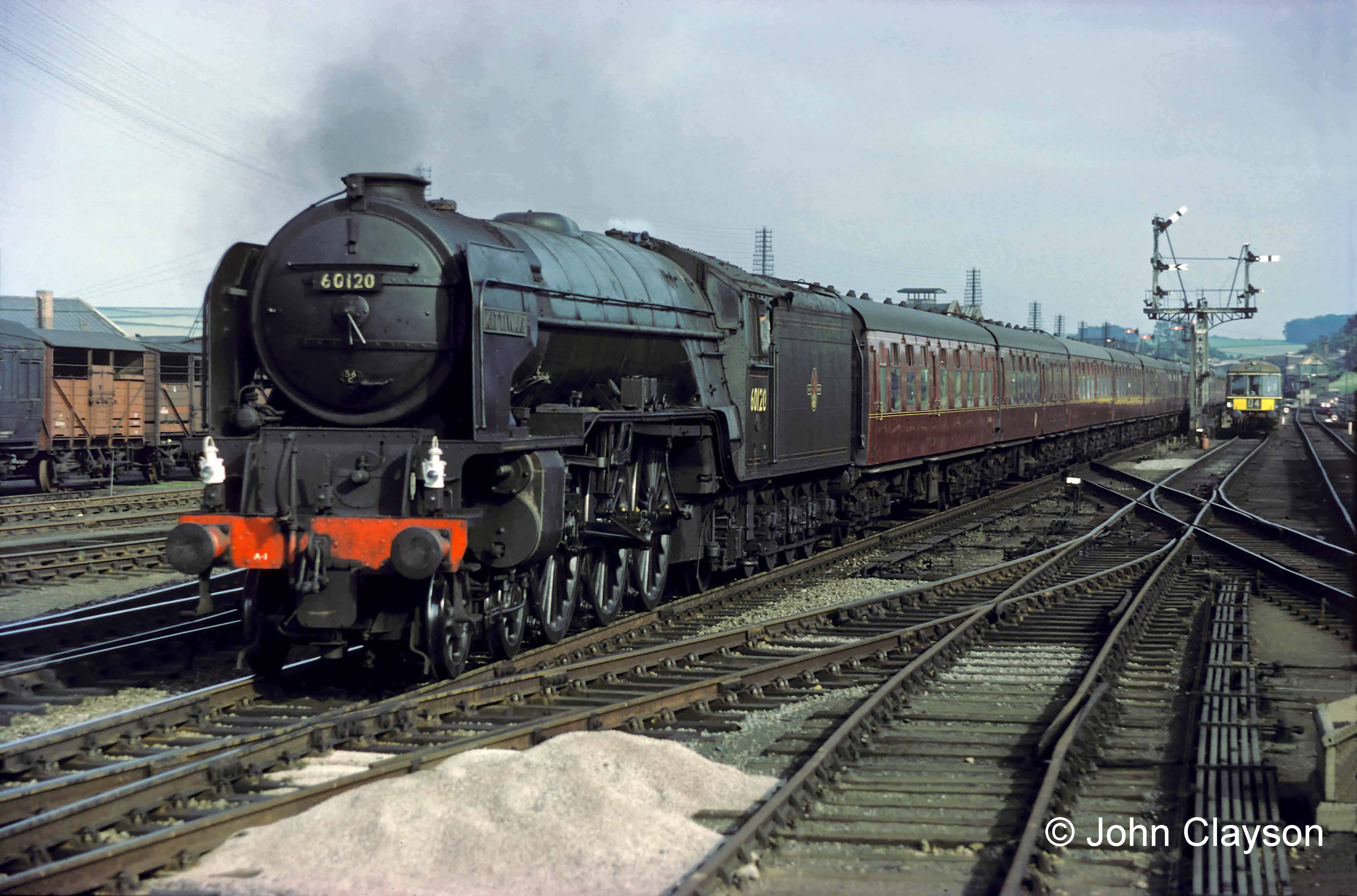 This northbound train is signalled to stop in the station because the Grantham North box distant signal is at 'caution'. The driver of the railcar (diesel multiple unit) on the right has stopped on the Down Slow line waiting for one of the right hand signals to clear, which will allow it to run into the Western platform. The South Box can be glimpsed in the distance, immediately to the right of the railcar. Photograph taken in late June 1962 by Cedric A. Clayson.