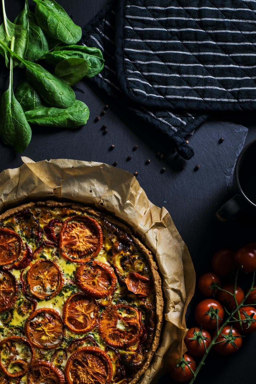 pizza with tomatoes on black surface