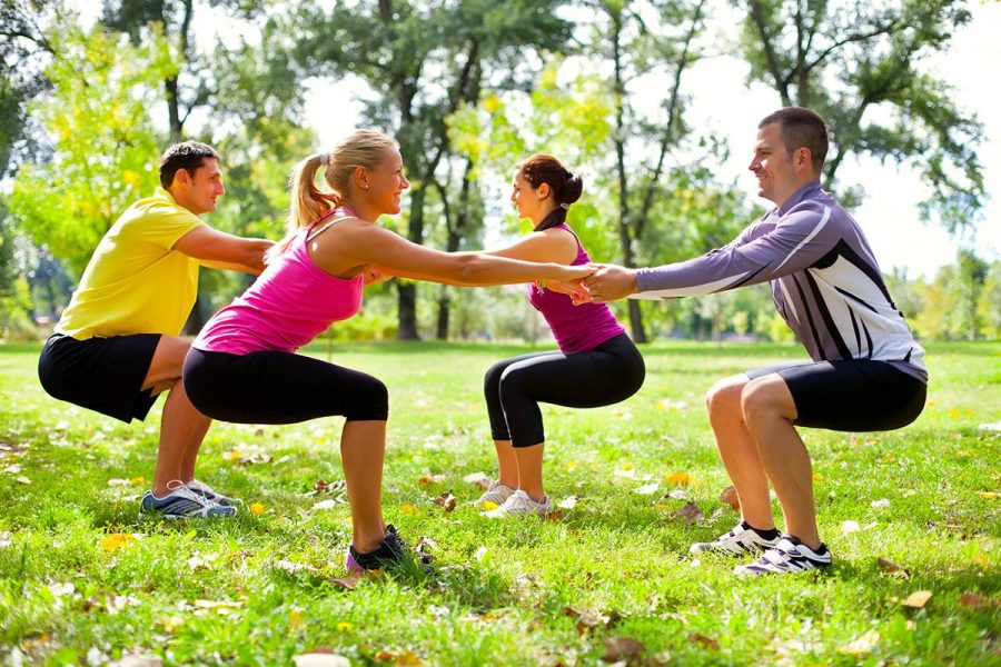 Group of people doing squats on a morning sunshine