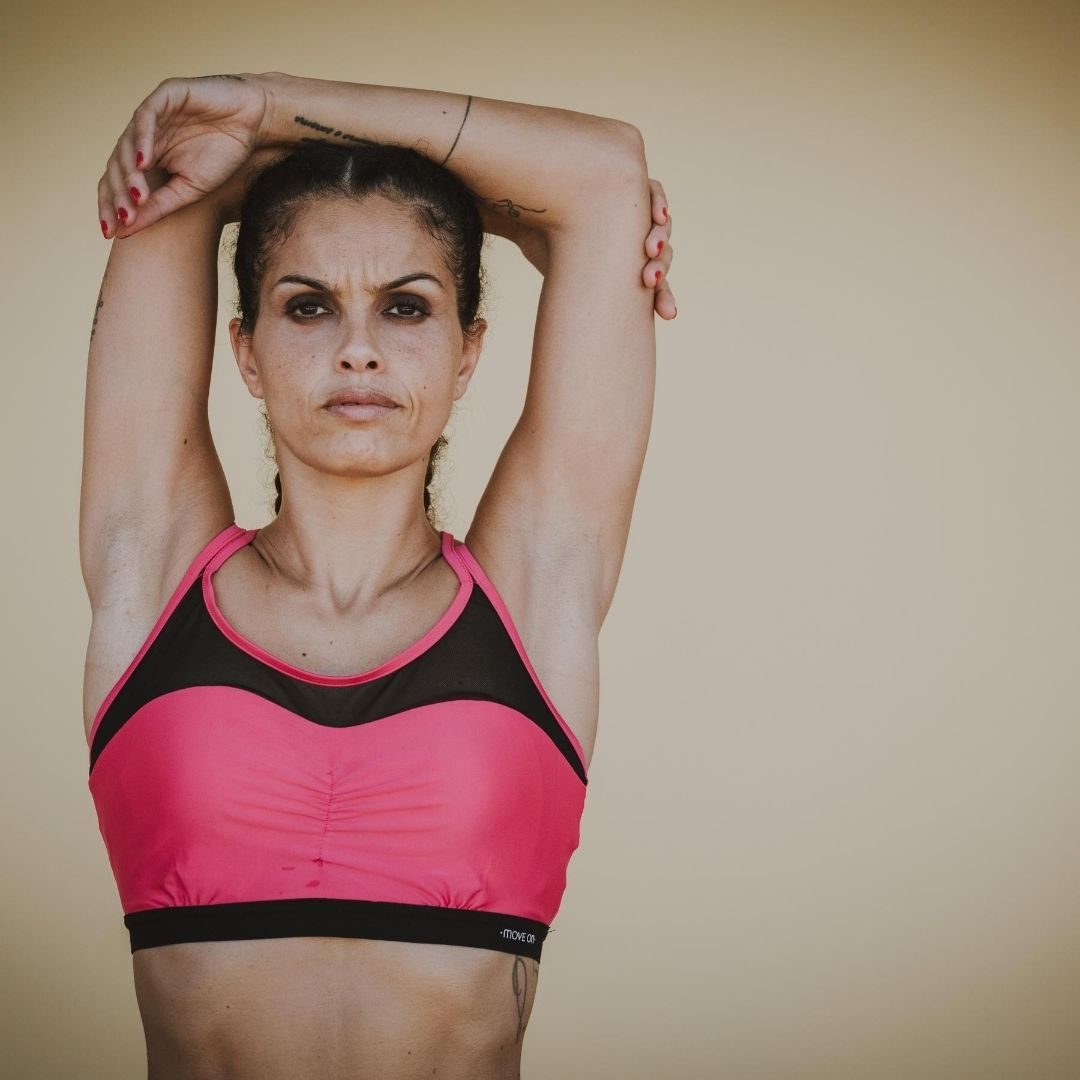 Trainer Donna Donna sportiva con le braccia in alto appoggiate sulla testa