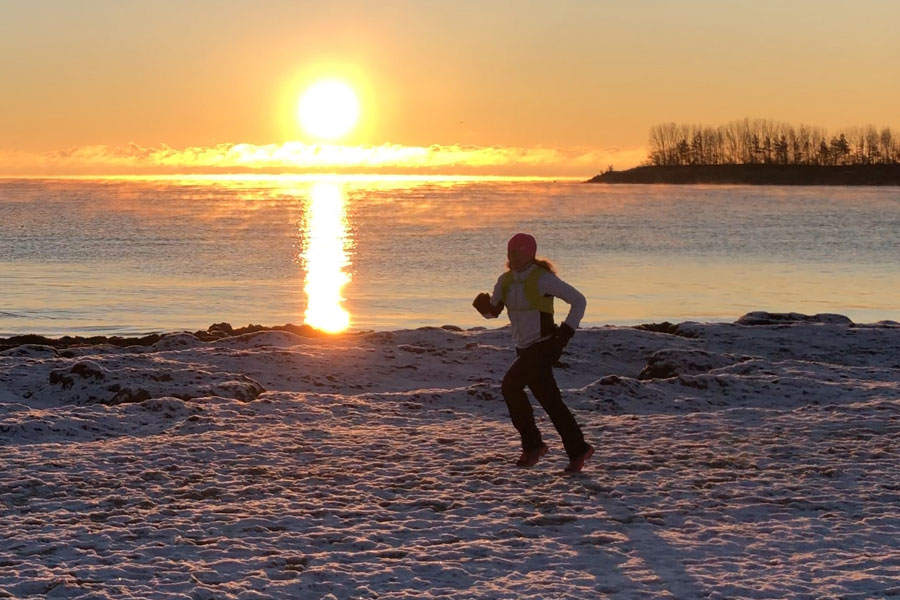 Vinterlöpning i soluppgång på stranden