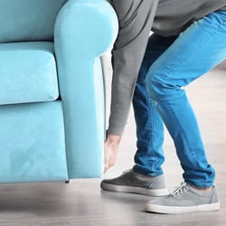 man moving a blue sofa