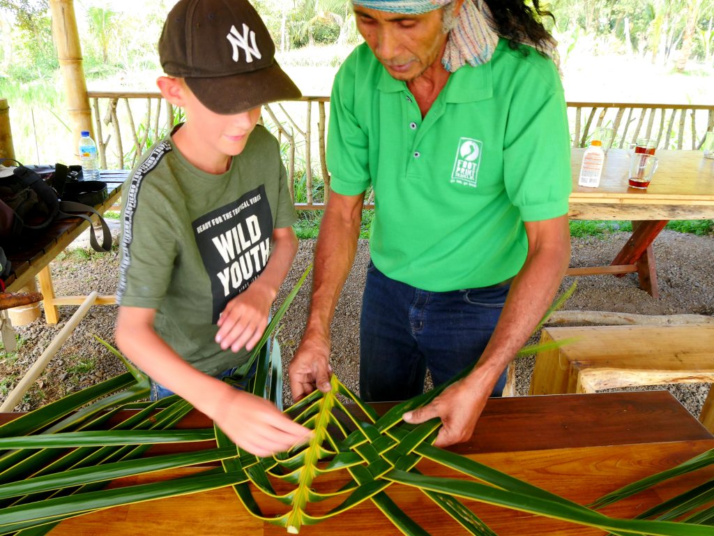 Erwin leert Bas en Siep een tas te vlechten van palmbladeren
