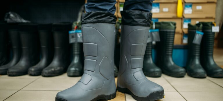 Fisherman tries on rubber boots in fishing shop