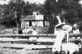 Mating av griser på Sørbysetra i Trømborgfjella i Eidsberg i 1919. Aagot Trømborg (g. Klerud) mater griser. Jentene Gerd og Edith fra Drammen ser på. Foto: Johan Svenneby.