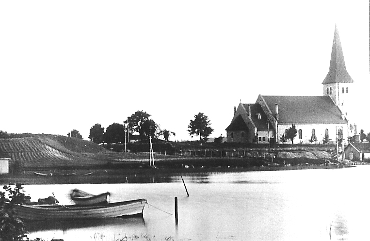 Tune kirke i 1920. Tunevannet i forgrunnen med Klokkerød til venstre. Foto: Sarpsborg kommunes fotoarkiv