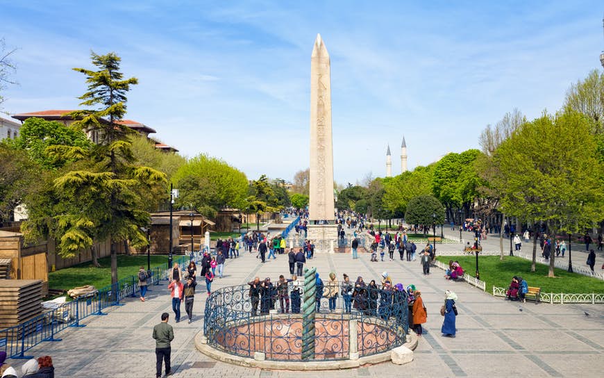 Människor som går nära berömda landmärken Obelisk of Theodosius och Serpent Column på Hippodromen i Istanbul, Turkiet