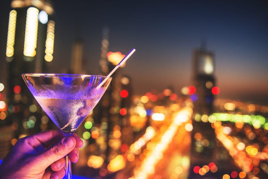Martiniglas med Dubais ljus i bakgrunden