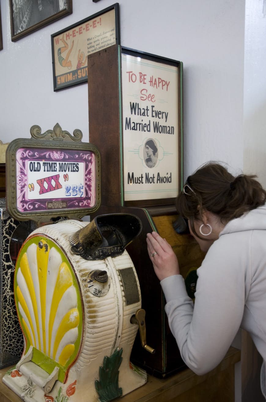 En kvinna tittar igenom ett vintage arkadspel på en av de bästa gratis sakerna att göra i San Francisco