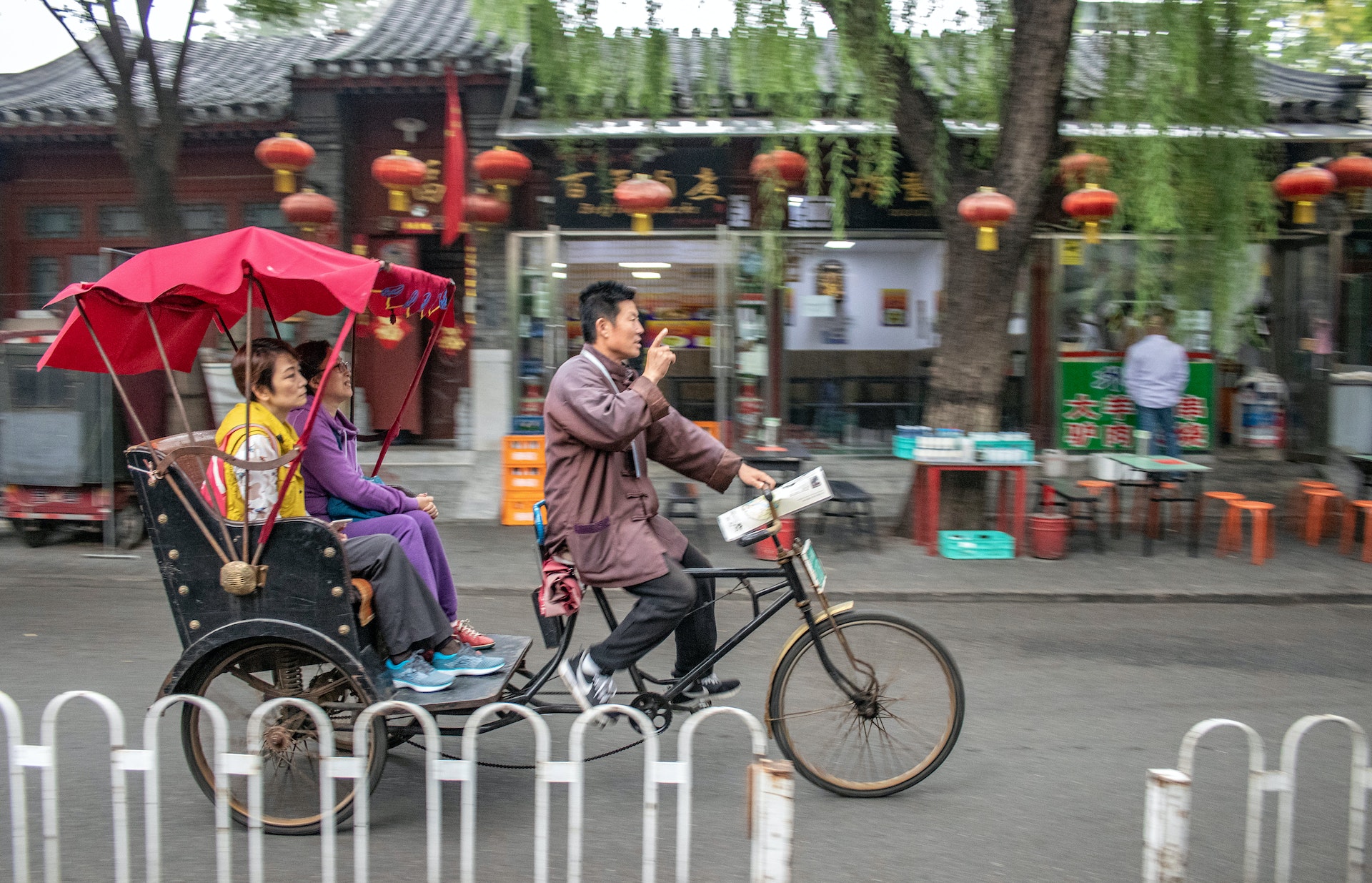 En rickshaw driver turister runt i ett hutongdistrikt i Peking under den kinesiska gyllene veckan