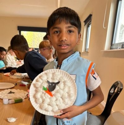 Photo of boy showing off his marvellous sheep design on a plate.