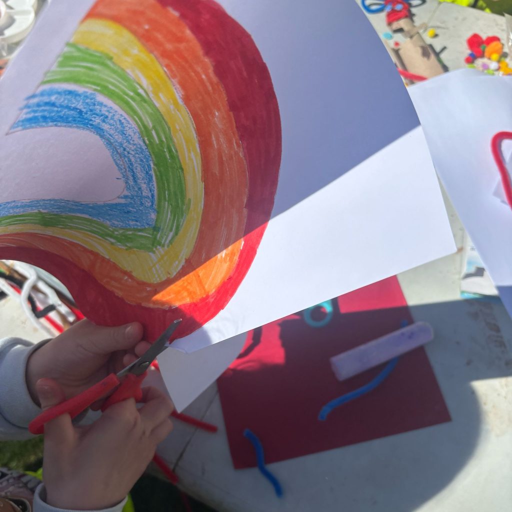 Photo of painting of rainbow being cut with scissors