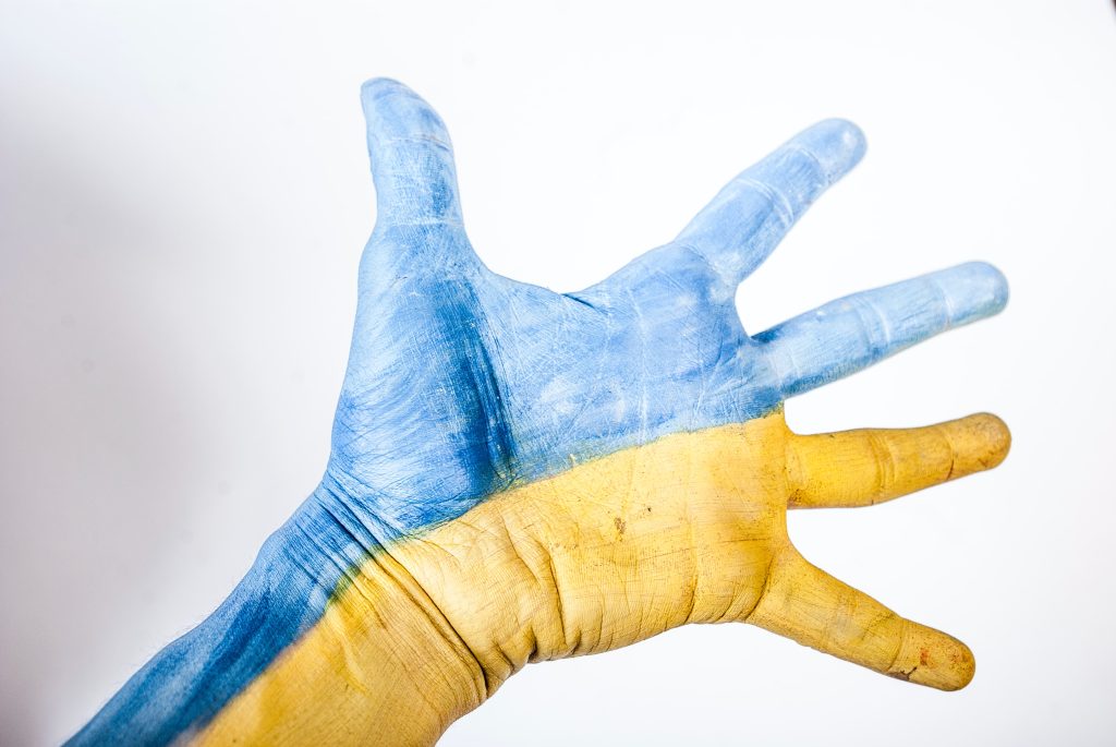 En utsträckt hand målad i ukrainas färger