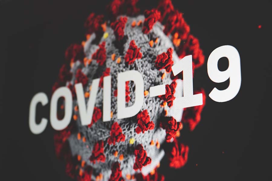 The words 'COVID-19' written across a background image of a human cell
