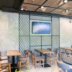 Modern urban interior of restaurant with grass walls and designed furniture