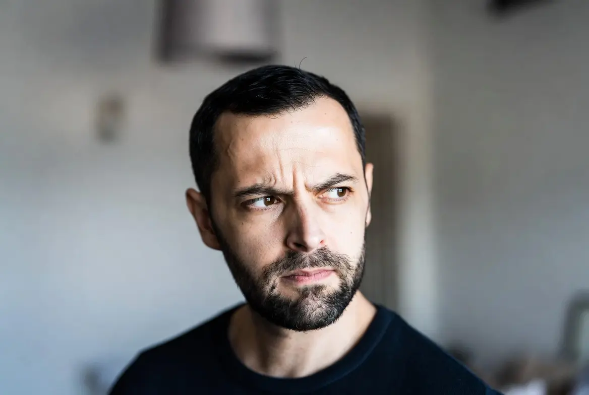 Person with subtly narrowed eyes showing cautious evaluation, illustrating narrowing eyes meaning.