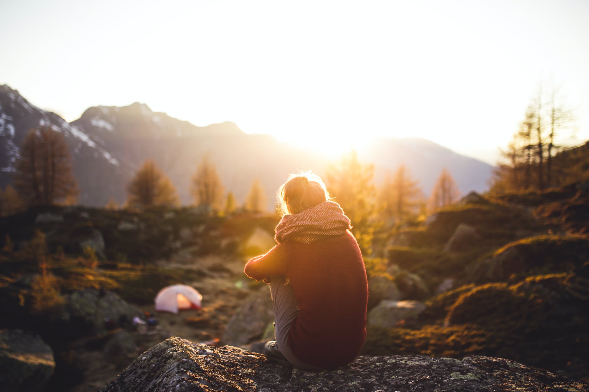 person sitting on rock at golden hour