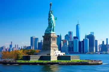 statue-liberty-stands-front-city-skyline statue-liberty-stands-front-city-skyline