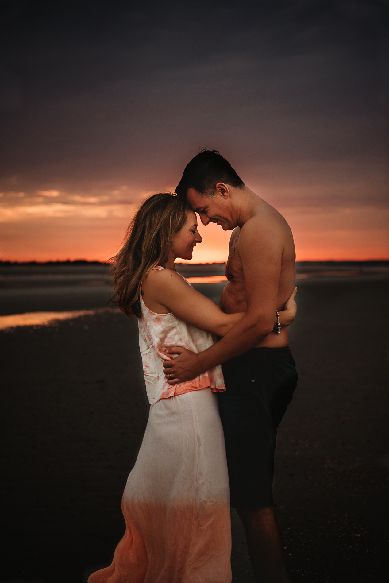 Couple hugging in West Wittering Beach with West Sussex engagement photographer