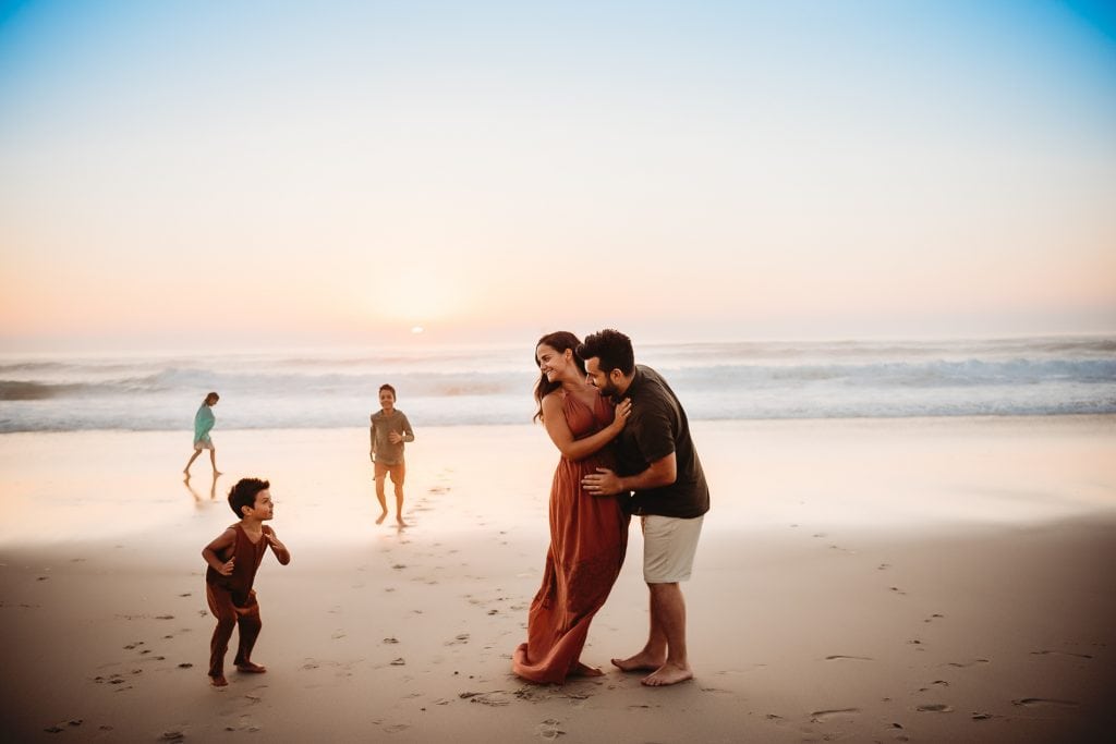 family playing on the beach at sunset with West Sussex photographer