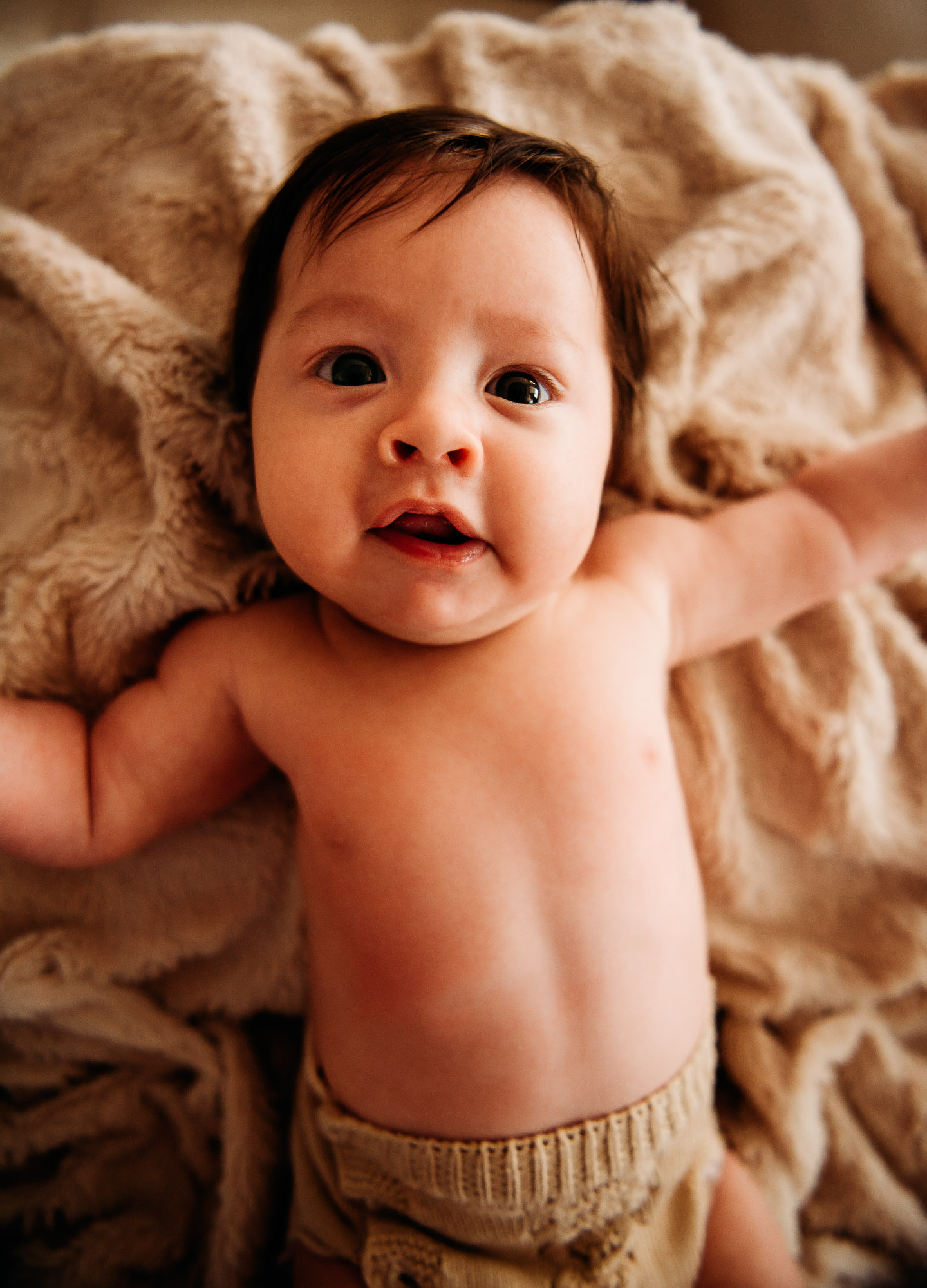 Baby smiling with West Sussex baby photographer during at home newborn photography session